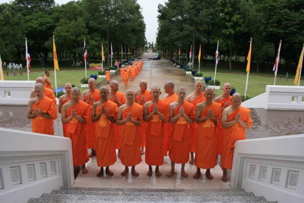 A procession of Buddhist monks in orange robes