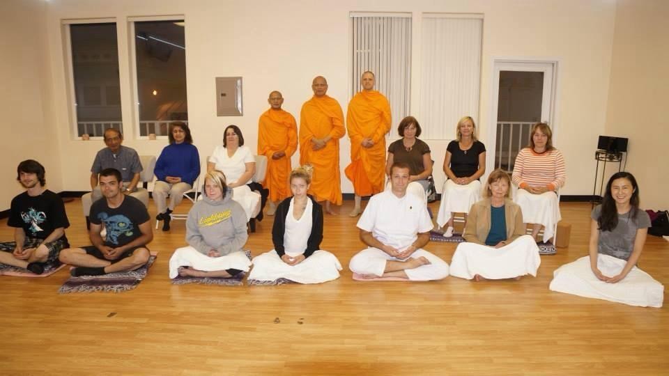 A meditation class with monks and students seated on the floor