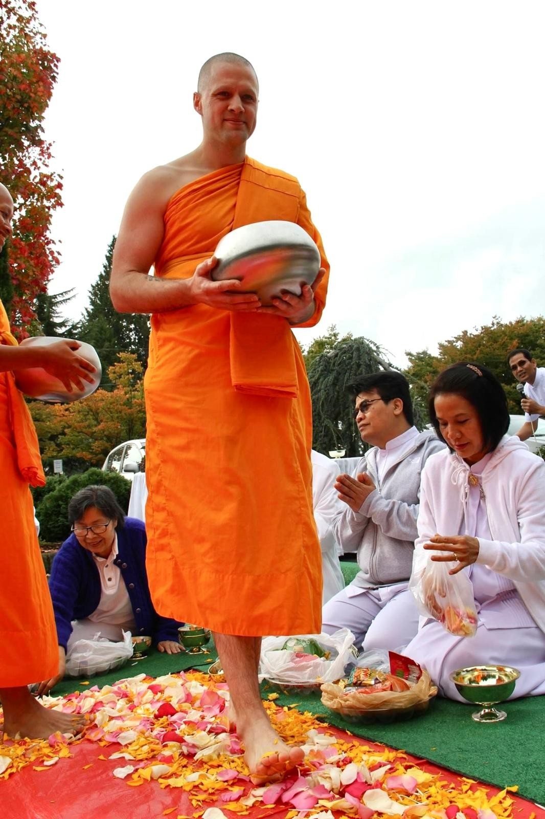 Steve Pinney Jr as a Buddhist monk, walking barefoot on flower petals with an alms bowl