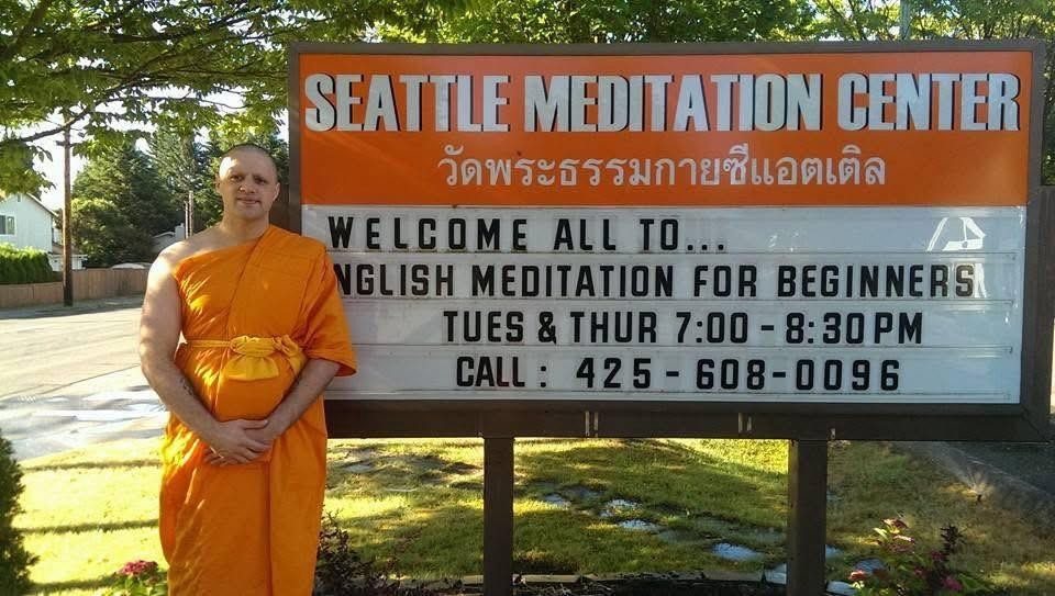 Steve Pinney Jr as a monk beside the Seattle Meditation Center sign